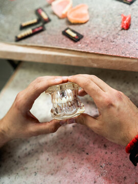 A dental technician creates a denture model in a dental office.