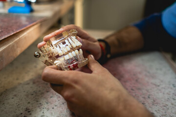 A dental technician creates a denture model in a dental office.