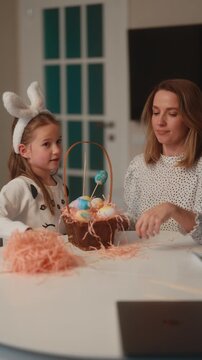 Joyful Mother and Daughter Preparing Colorful Easter Eggs in a Festive Basket