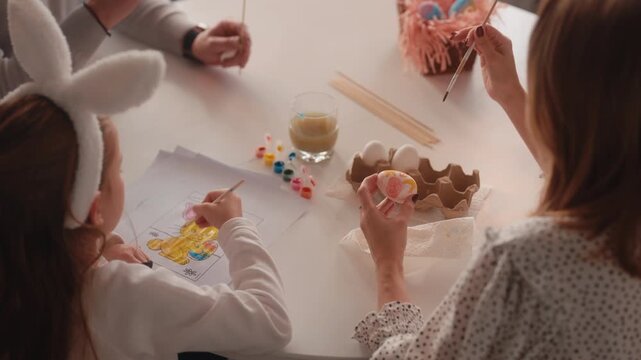 Family Enjoying an Easter Tradition, Coloring and Painting Eggs with Joy and Creativity