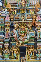 Obraz premium A vibrant section of Sri Mahamariamman Temple shows a richly layered façade filled with sculpted deities and celestial figures arranged across multiple tiers.