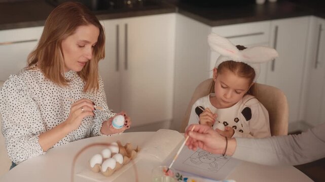 Happy Family Together Decorating Colorful Easter Eggs with Mother and Daughter for the Holiday