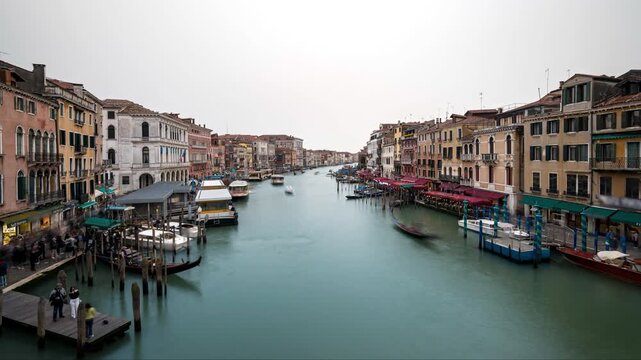 Grand canal in Venice timelapse with gondolas and boat traffic and tourists on an overcast day from Rialto bridge