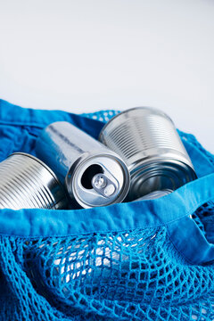 Close-up of eco friendly shopping concept with reusable mesh bag and metal cans.