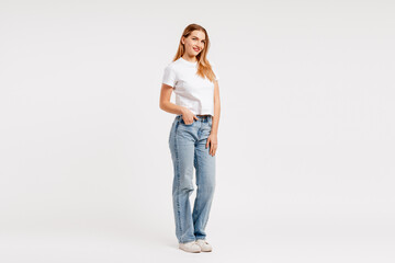 Confident young woman posing full length in casual white t shirt and blue jeans © Maria Vitkovska