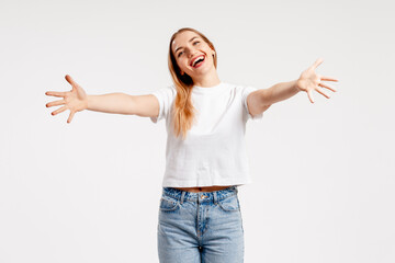 Happy young woman smiling, welcoming viewer with open, outstretched arms