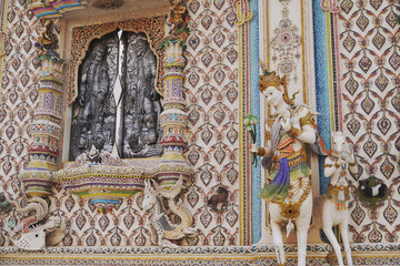 The contemporary stucco artwork in the Ordination Hall of Wat Pariwat Ratchasongkhram blends concepts related to beliefs and philosophy. Located at Bangkok city in Thailand.