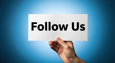 Hand Holding 'Follow Us' Sign on Blue Background: Digital Engagement and Social Media Marketing Concept for Business Development and Advertising Hand