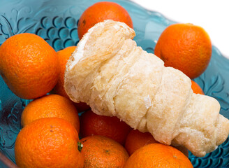 Tangerines and cakes in a vase.