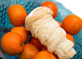 Tangerines and cakes in a vase.
