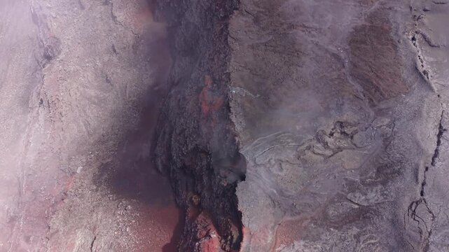 Drone footage moving forward past the Crater viewpoint at Piton de la Fournaise on Reunion Island. Dense fog drifts across the volcanic landscape as the drone advances