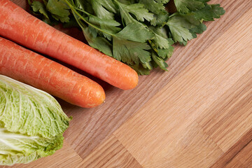 Ingredients for making salad, cabbage, carrots and parsley on a cutting board.