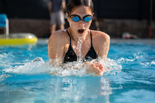 Girl performing breaststroke in swimming pool, healthy lifestyle activity