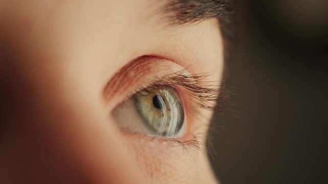 Close-up of woman blinking eye with green iris.