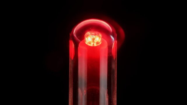 A red light emitting diode glowing brightly in the dark