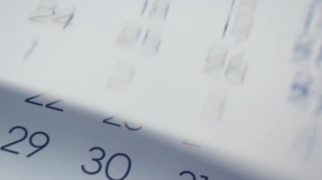 Time passing and inevitable changings concept. Close Up of paper calendar with pages turning quick