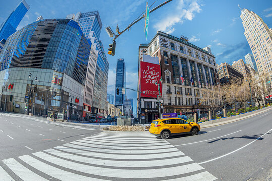 Buildings and traffic in Manhattan with typical yellow taxi seen from the street level. In background is the store Macys, the worlds largest store, New York, USA