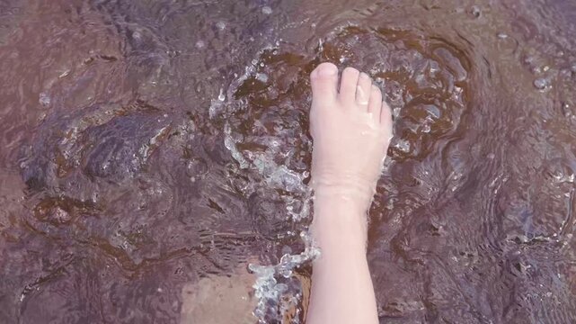 closeup bare feet child or preteen standing in clean clear water, young explorer, stones rocky shore or riverbed summer vacation, childhood river play, outdoor fun, child and nature, eco awareness
