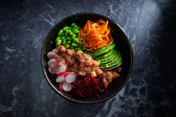 A bowl of food with a variety of vegetables and meat
