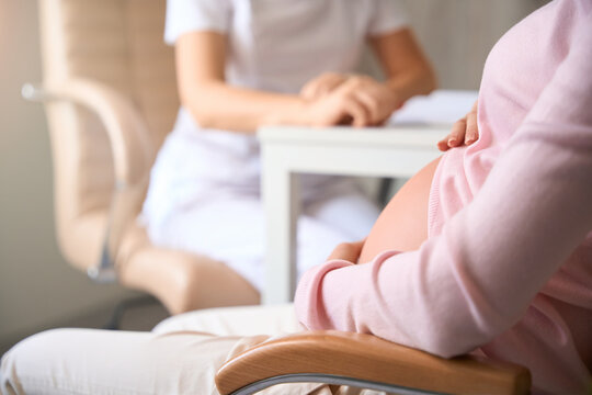 Unrecognizable woman gynecologist supports pregnant female