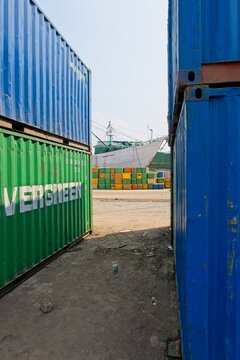 Jakarta Indonesia - 20 July 2025 - Stacked sea containers in the old harbor Sunda Kelapa with wooden cargo ships in Jakarta Indonesia
