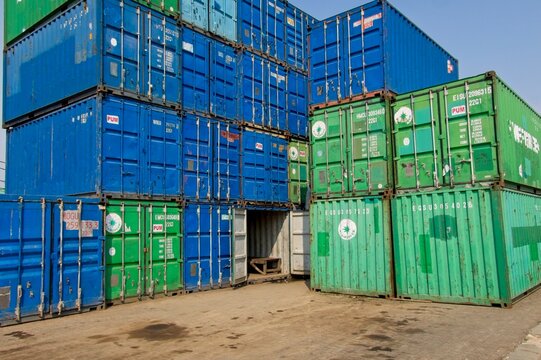 Jakarta Indonesia - 20 July 2025 - Stacked sea containers in the old harbor Sunda Kelapa with wooden cargo ships in Jakarta Indonesia