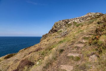 Along the South West coast path on the Penwith Peninsula, with a blue sky overhead