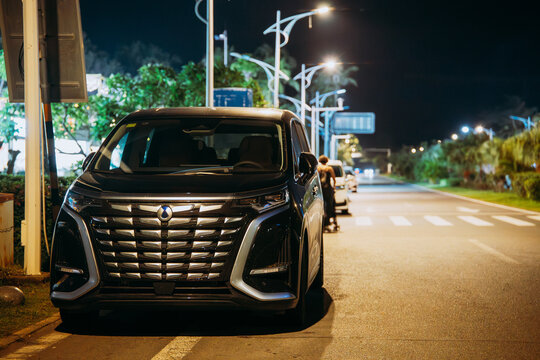 Luxury black Denza D9 electric minivan on night city street