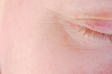 Fototapeta premium Extreme close-up of a closed human eye showing delicate skin texture and eyelashes