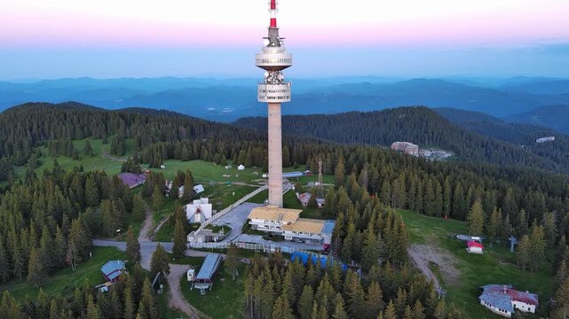 Tower Snezhana on peak of Snezhana covered with spruce forests in Rhodope mountains