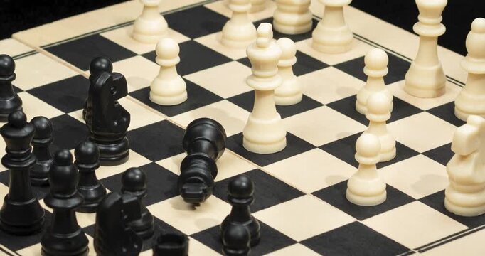 A Zoom out of a white king chess piece check mate over a chess board in a victory concept