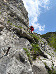 A via ferrata hike at the mountains with a dangerous vertical stone wall