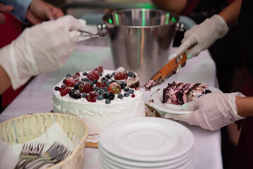 Osoba w rękawiczkach serwuje tort owocowy © Katarzyna