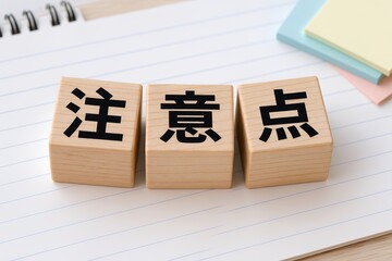 ノートの上に並べた木製ブロックで注意点や重要事項を分かりやすく示す確認イメージ