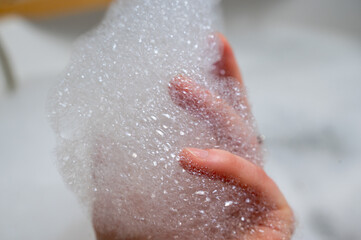 Fototapeta premium Tactile moment of soft bubbles and skincare enthusiasm vividly documented