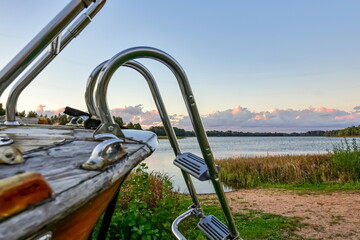 The bow of a boat against the backdrop of a sunset lake