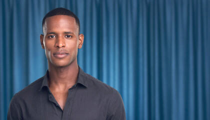 portrait of a man with a blue curtain backdrop