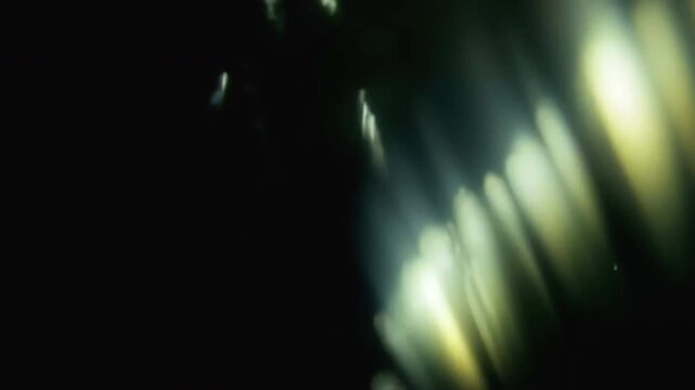 Abstract blurred light leaks on dark background with copy space. Studio anamorphic lens flare bokeh effect for title or logo display.4k video