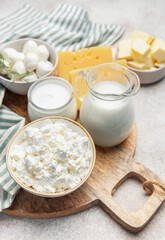 Assortment of fresh dairy products on wooden cutting board