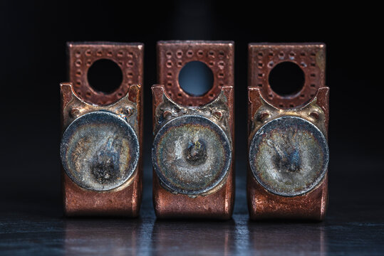 Close up of copper electrical contactor components with patinated silver contacts. Industrial use of non ferrous metals in electrical power and energy systems.