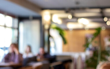 Cozy cafe interior with blurred diners and warm lighting in a modern, casual setting