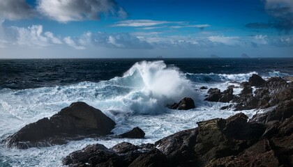 Fototapeta premium Powerful Waves Crash Against Dark Coastal Rocks