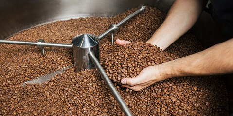 High detail shot of male hands, coffee beans, and the  cooling drum of a roasting machine © Artem Varnitsin