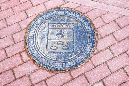 Metal manhole cover on the city street. Text in russian: Murom
