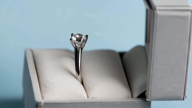 Engagement ring in open jewelry box on light background, elegant diamond ring presentation for proposal and wedding concept