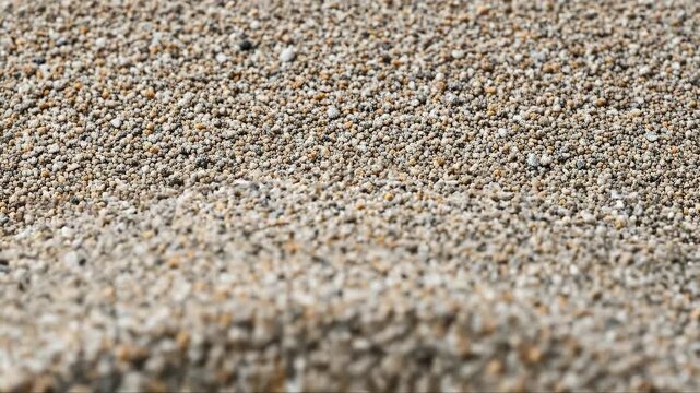 Zooming in on smooth pebble beach with gentle ripples and textured patterns