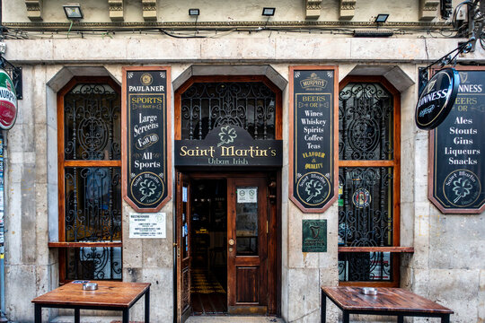 raditional facade of Saint Martin's Urban Irish Pub in Valencia, Spain, featuring ornate wrought iron window guards and painted menu boards.