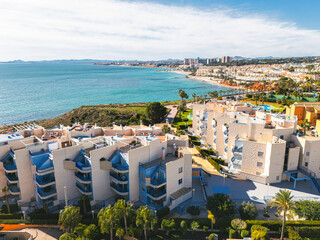 Aerial panoramic view of Coastal apartments overlooking Mediterranean Sea in sunny resort town of Cabo Roig, Costa Blanca, Province of Alicante. Spain