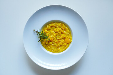 Overheard shot of Creamy pumpkin risotto on white background 