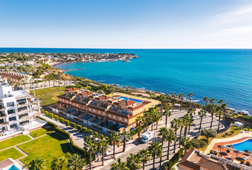 Aerial view Cabo Roig coastal town on southern Costa Blanca, Mediterranean Sea and seafront residential buildings during sunny day. Province of Alicante. Spain